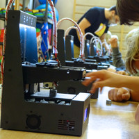Młodzież pracuje przy drukarkach 3d
