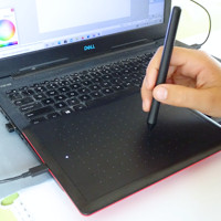Dziecko pracuje przy komputerze i tablecie graficznym